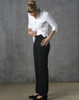 Black low rise pants made from poly/viscose stretch material, paired with a white shirt. The model is adjusting the pants.