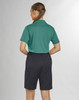A woman in a green polo shirt and black utility cargo shorts, viewed from the back. The shorts have pockets and are knee-length.