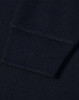 A close-up view of the cuff of a navy blue polo shirt featuring a ribbed design and a logo.