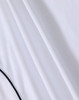 A white polo shirt with a textured fabric and contrasting detailing, featuring a logo.