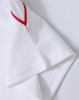 A white polo shirt featuring red detailing on the sleeves, with a branded logo.