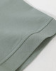 A close-up of the hem of a men's cotton stretch polo in a soft green colour, featuring a knitted cuff.