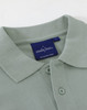 A mint green men's cotton stretch polo shirt featuring a collar and buttons, with a branding label inside.