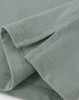A close-up view of a light green men's cotton stretch polo shirt, highlighting the fabric and stitching details.