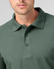 A green men's cotton stretch polo shirt featuring a classic collar and button placket, with a logo on the chest.