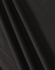 A close-up of black fabric showcasing texture and drape, featuring a subtle weave pattern.