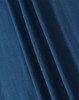 A close-up of blue fabric showcasing the texture and folds of a pique polo shirt. The image features a logo.
