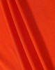 A close-up of orange fabric featuring a textured surface, ideal for polo shirts. The image includes a logo.