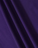 A close-up of fabric in a rich purple hue, showcasing the texture and depth of the material.