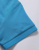 A close-up of a turquoise polo shirt sleeve, featuring a textured fabric and a logo.