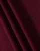 A close-up of maroon fabric, showing a textured weave with draped folds.