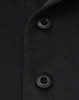 A close-up of a black polo shirt featuring two black buttons and a collar. It has a logo on the fabric.