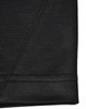 A close-up of a black polo shirt featuring a smooth fabric texture and detailed stitching.