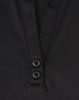 A close-up of a black polo shirt featuring a collar and two buttons at the neckline. The shirt has a logo.