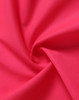 A swirl of bright pink fabric, showcasing a textured surface ideal for safety apparel.