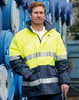 A Hi-Vis long line safety jacket in bright yellow and navy, featuring reflective 3M tapes, worn by a person.