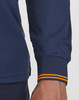 A close-up of a navy blue long-sleeved polo shirt with segmented orange-striped cuffs, featuring a logo.