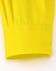 A close-up of a yellow long-sleeved shirt sleeve cuff, featuring a smooth fabric and a logo.