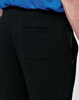 Black poly/cotton terry sweat pants with a pocket, featured on a model's side view.