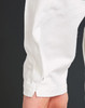 A close-up of a white sleeve of a garment, highlighting the stitching and fabric texture.