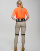 Rip-stop poly/cotton stretch work pants in beige, featuring a logo, worn with an orange shirt. View from the back.