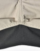 A close-up of Rip-Stop poly/cotton stretch work pants, featuring a beige upper section and a black lower section with stitching.