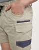 Work shorts in beige with dark navy accents, featuring pockets and an elastic waistband. The shorts have a logo.