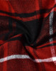 A close-up of red and black plaid flannel fabric with white stripes, showcasing a soft, quilted texture.