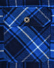 A close-up of a blue and white quilted flannel shirt featuring a pocket with a snap button. It has a plaid pattern.