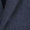 A blazer in a textured navy blue fabric, showcasing a subtle woven pattern. Features a logo on the label.
