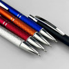 A group of five plastic pens in red, orange, blue, silver, and black, featuring chrome accents and a textured grip.