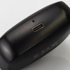 A black charging case with a USB-C port, used for wireless earbuds. The case has a sleek design and minimal branding.