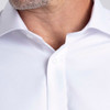 A white button-up shirt with a collar, featuring a subtle texture and a logo on the chest area.