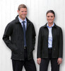 A men's and women's black soft shell jacket displayed on two models against a white wooden background. Each jacket features a logo.