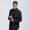 A black trench coat jacket with a stylish collar, featuring a logo on the sleeve and modelled by a man.
