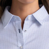 A close-up of a women's button-up shirt featuring a blue and white check pattern, with a collar and buttons.