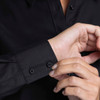 A black button-up shirt featuring a close-up of the cuff and buttons.