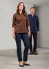 A brown long sleeve button-up shirt worn by a woman, paired with dark trousers and complemented by a man in a navy shirt.