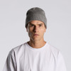 A grey knit beanie being worn by a model in a plain white T-shirt against a neutral background.