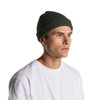 A green ribbed beanie worn by a man, featuring a snug fit and a logo on the side.