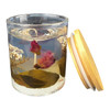 A floral candle in a clear glass jar features dried pink roses and white flowers, with a wooden lid nearby.