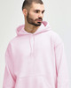 A model wearing a pink Gildan Heavy Blend Adult Hooded Sweatshirt with the hood up.