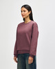 A maroon hoodie with a relaxed fit, featuring long sleeves and a simple design, displayed on a model.