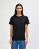 A heavyweight cotton unisex T-shirt in black displayed on a model, featuring a simple design and short sleeves.