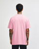 A pink heavyweight cotton unisex T-shirt displayed from the back. The shirt features a logo.