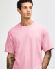 A unisex heavyweight cotton t-shirt in pink, featuring a round neckline and short sleeves. It has a logo.