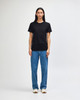 A black heavyweight cotton unisex T-shirt displayed on a model, paired with green cargo pants and sneakers.