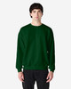 A green Gildan Heavy Blend adult crewneck sweatshirt on a model, featuring a plain design and long sleeves.