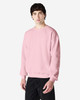 A pink Gildan Heavy Blend adult crewneck sweatshirt displayed on a model, featuring a logo.