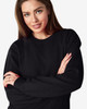 A black Gildan Heavy Blend Adult Crewneck Sweatshirt displayed on a model with long hair, crossing her arms.